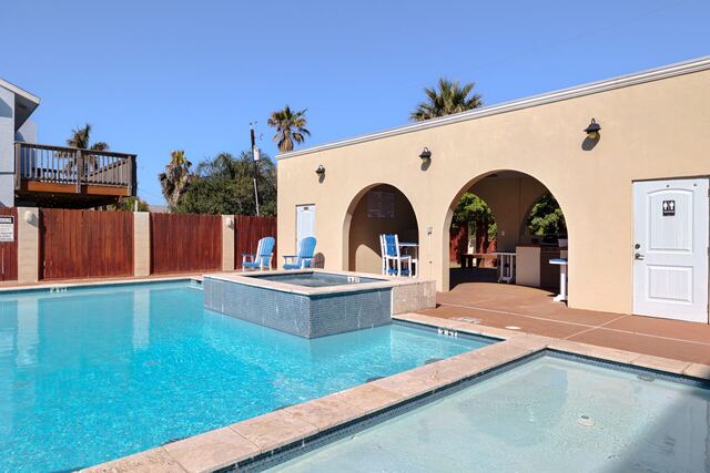 Pool with arches and palms at Athena Ares Seaside Estate, South Padre Island